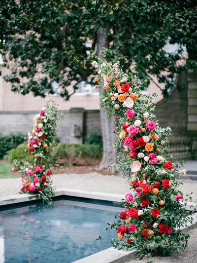 Colorful floral arch over reflecting pool 