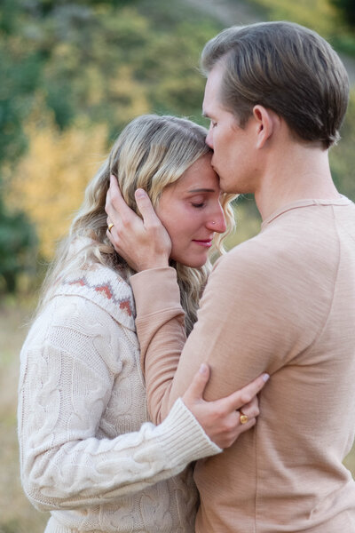 Husband kisses wife in a tender moment in Cottonwood Canyon, Utah