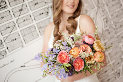 Colourful bridal bouquet of purple, pink, orange and yellow flowers, by Flowers By Janie, artful Calgary, Alberta wedding florist, featured on the Brontë Bride Vendor Guide.