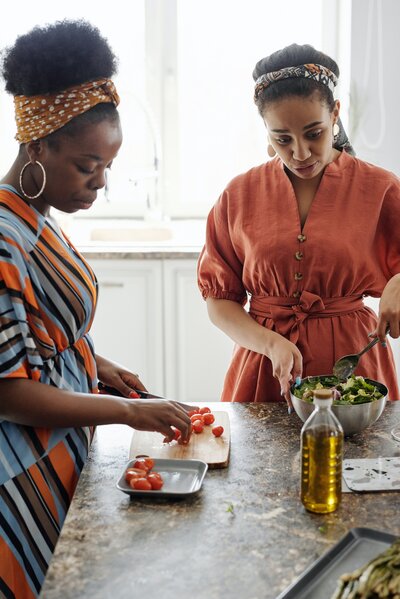 Two women of african descent cooking in the kitchen to help with their menopause