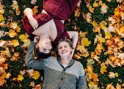 Fall engagement photo of Missoula couple laying on grass