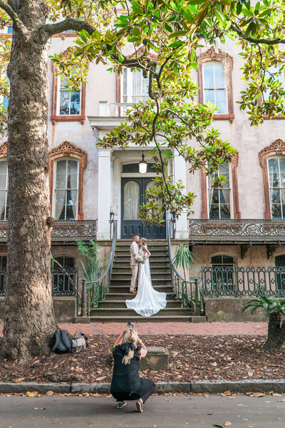 A joyful elopement portrait taken on a bench Forsyth Park, capturing a romantic Savannah moment."