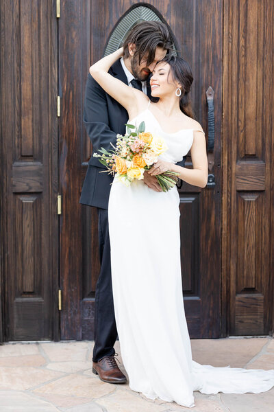 Bride and groom in front of church doors. A Phoenix wedding photographer