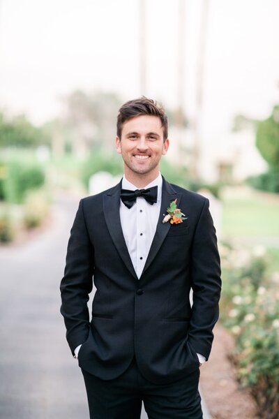 Groom standing straight on to camera smiling