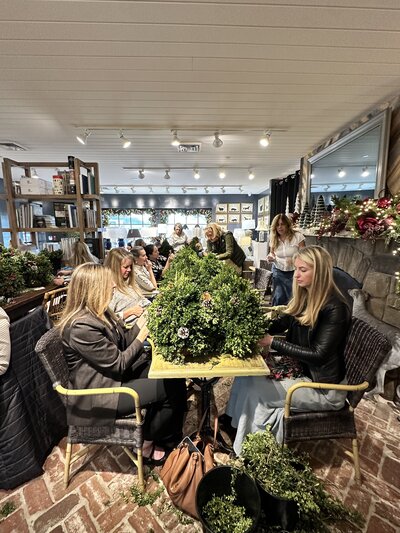 women sitting at table decorating trees