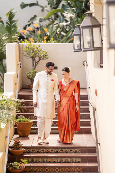 Bride and Groom holding hands and walking down the steps at their wedding at Estancia Hotel and Spa wedding venue