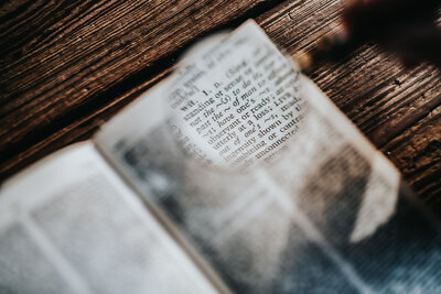 BYOBrand Podcast Host Hannah Ellaham Site Image of Book On Raw Wood Magnifying Glass highlighting the Word Wit In The OED dictionary