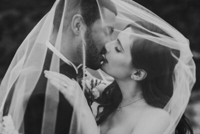 black and white photo of wedding couple kissing