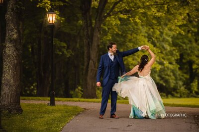 Bride and groom twirl in the park