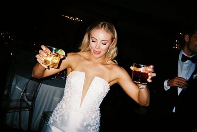 Flash film photo of bride with drinks in both hands