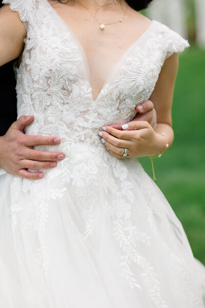 The Corteses Newport Wedding Photographer and Videographer | Serving CT, RI, and beyond | Bride and groom belly button to belly button with bouquet around grooms neck with the ocean behind them