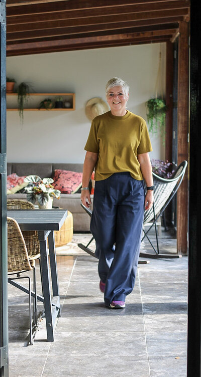 Threa van LOOSZ Interieur & Styling loopt door een sfeervolle tuin met natuurlijke materialen en warme accenten.