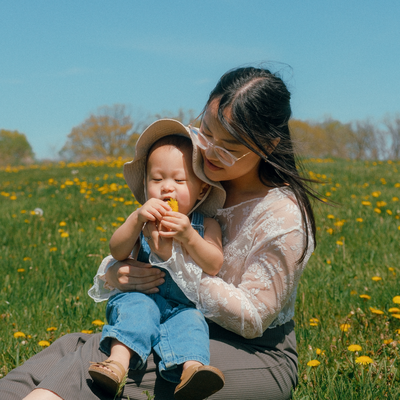 A photo of Cindy and her son in a field of dandelions.