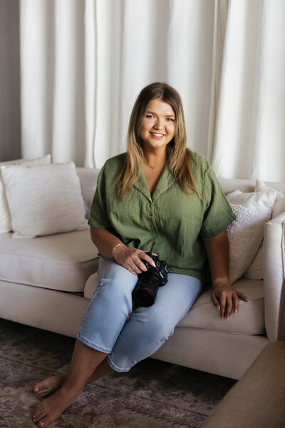 Courtney sitting on sofa holding Canon R6 Mark II Camera