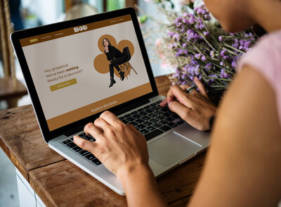 Women at her desk looking at a custom designed website on her laptop