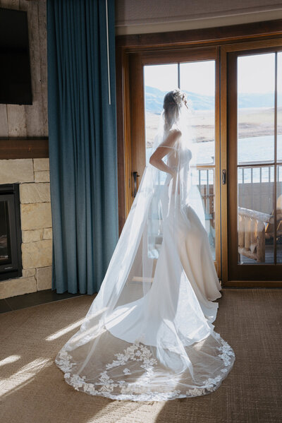 bride standing looking out window at sage lodge