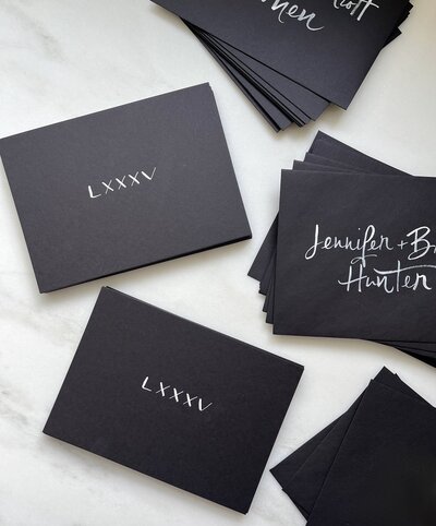 Black invitations  and envelopes with white calligraphy
