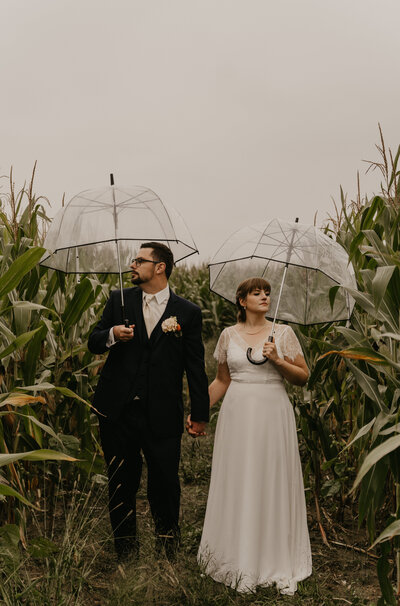Vintage fall, outdoor Wedding in Wisconsin. The couple is standing in a field of corn on their rainy wedding day.