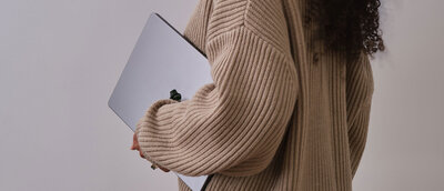 Woman holding laptop to her side