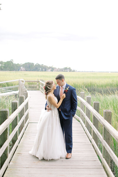 bride and groom standing on dock walkway