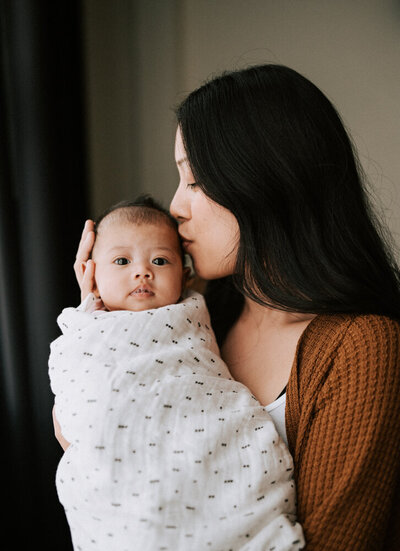 woman holding baby during session with Vancouver family photographer