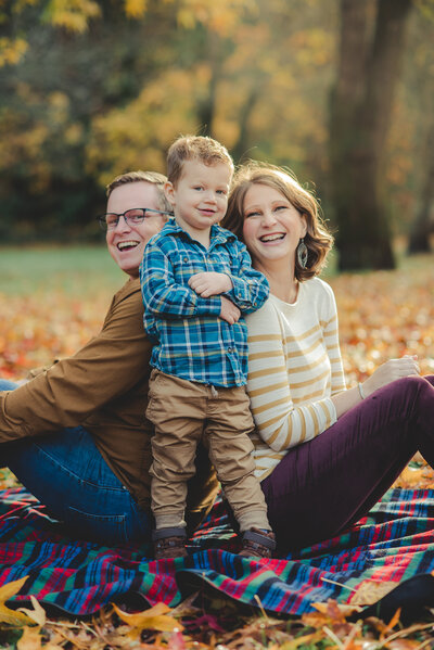 family with little boy on blanket