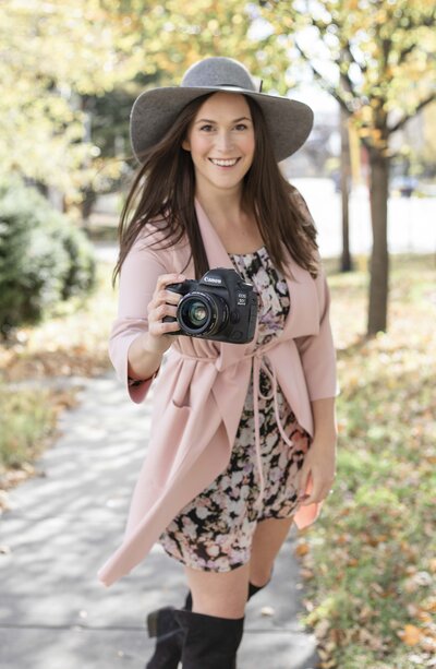 Business Coach for Photographers - Cassie Schmidt holding her camera.