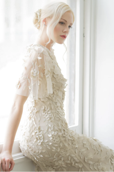 Bride posing with polished updo and radiant skin