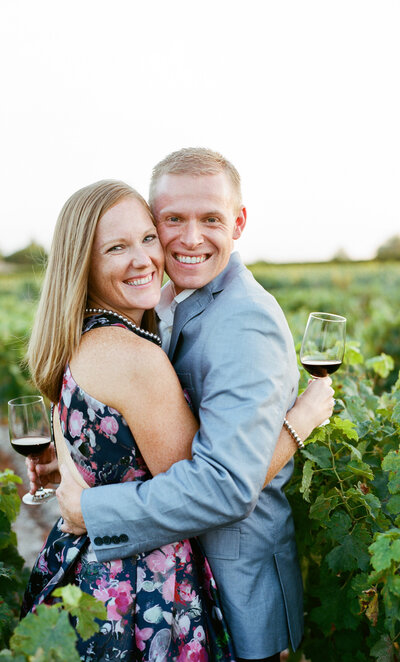 Couple Smiling pre-wedding with a glass of wine in the vineyard of Château Lynch-Bages