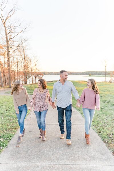 parents & teenage girls walking during their family pictures in Gainesville, VA taken by a family photographer in Northern VA