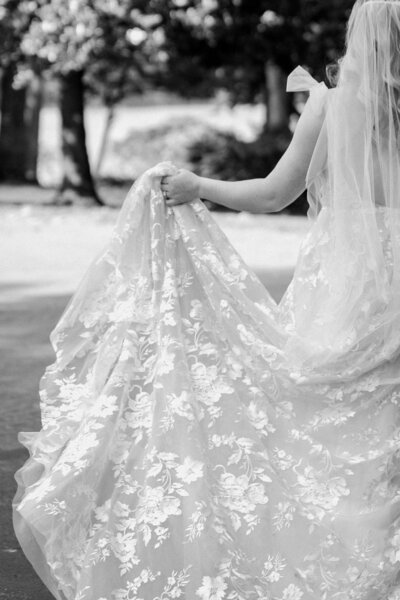 black and white image of girl holding wedding dress
