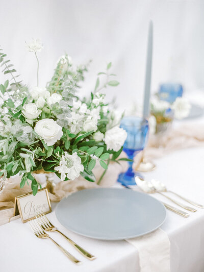 A romantic garden reception table set with elegant tableware and floral centerpieces.