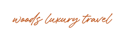 Text based logo in script font "Woods Luxury Travel"