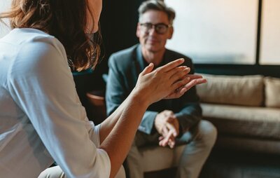 female gestures to man as they talk