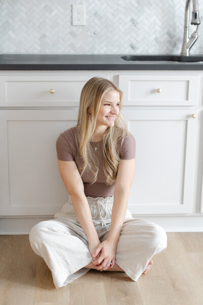 Sammie smiling and sitting next to kitchen cabinets