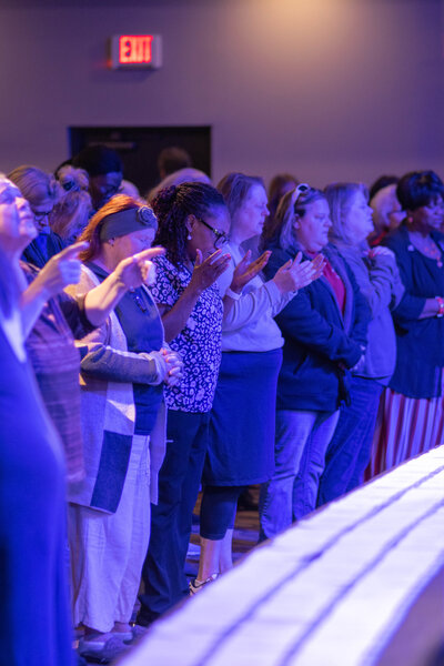 A multicultural group of people praying together at a non-denominational church in Fayetteville, NC. 