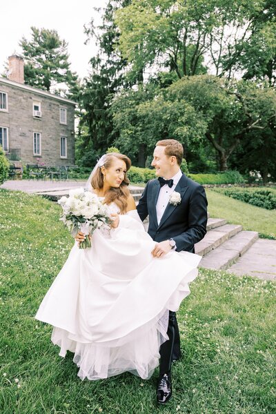 Bride and groom walking holding dress