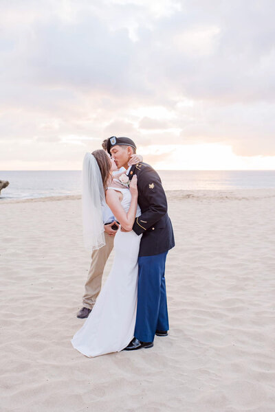 Hilton Hawaiian Village Wedding Photography, uniformed groom kissing bride at the beach