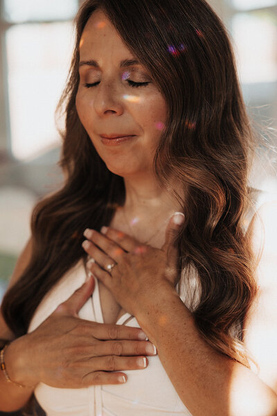 Patty with her eyes closed and her hands on her heart