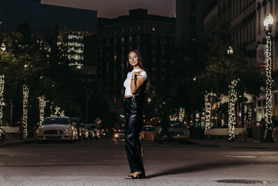 Nighttime downtown grand rapids senior posing in street with lights on Monroe Center.