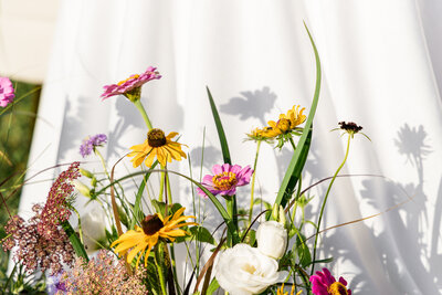 pink and yellow flowers against white tablecloth 