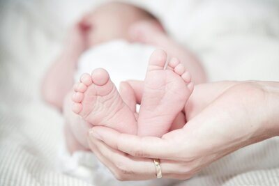 Photo of baby with feet being held up by parent in shape of heart