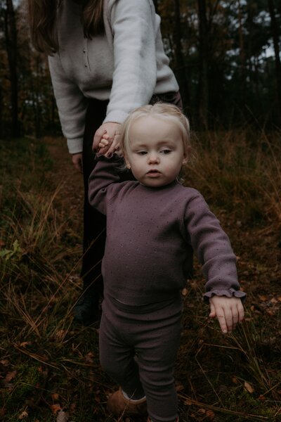 Vader en moeder zwaaien zoontje in het bos op de Ginkelse hei in Ede