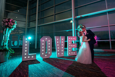 Couple kissing in front of a LOVE sign at The Bayfront Convention Center in Erie Pennsylvania.