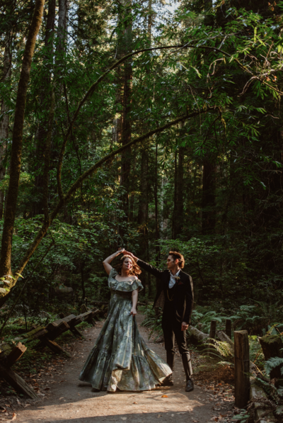 A couple twirls each other in the forest at Armstrong Redwoods State Park on their nontraditional wedding day