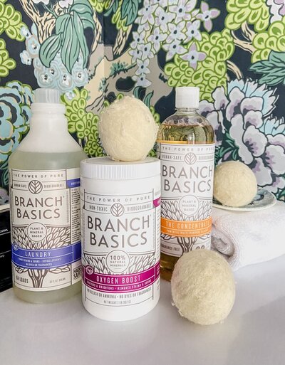 Bottles of natural cleaning products and dryer balls.