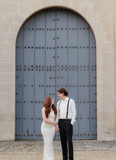 an estate engagement session in Ipswich Massachusetts. Bride with bright red hair and long white dress in front on blue door
