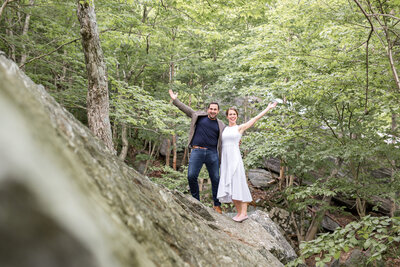 bride and groom standing on rock in the woods
