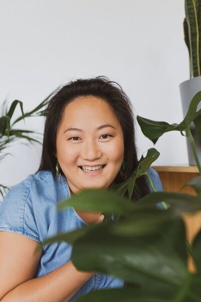 A woman smiling surrounded by plants