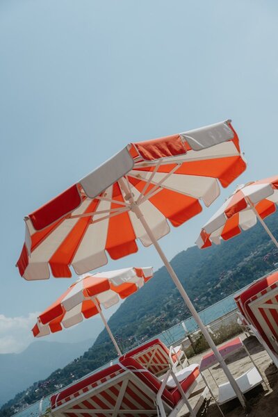 orange and white umbrellas at the beach of Lake Como